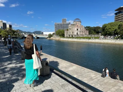 Kvinne som ser på Atombombekuppelen i Hiroshima, Japan.