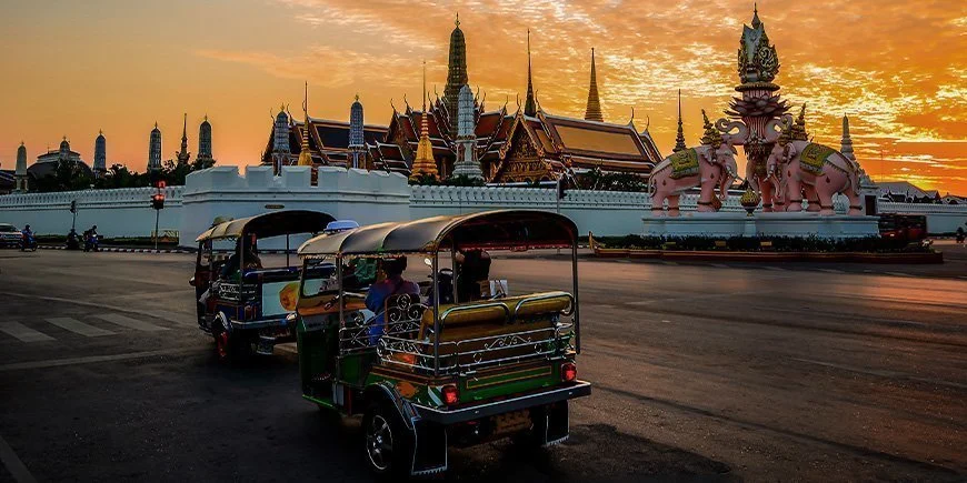 Tuk tuk med utsikt over et tempel i Bangkok