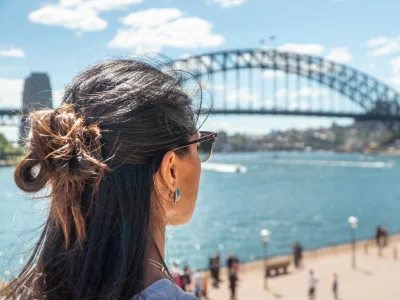Kvinne ser på Sydney Harbour Bridge i Sydney, Australia