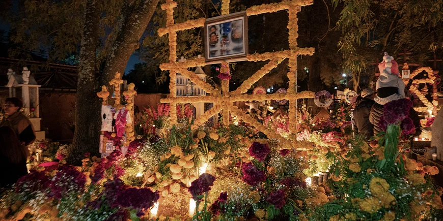 Gravsted pyntet med lys, bilder og andre dekorasjoner i forbindelse med De dødes dag i Mexico