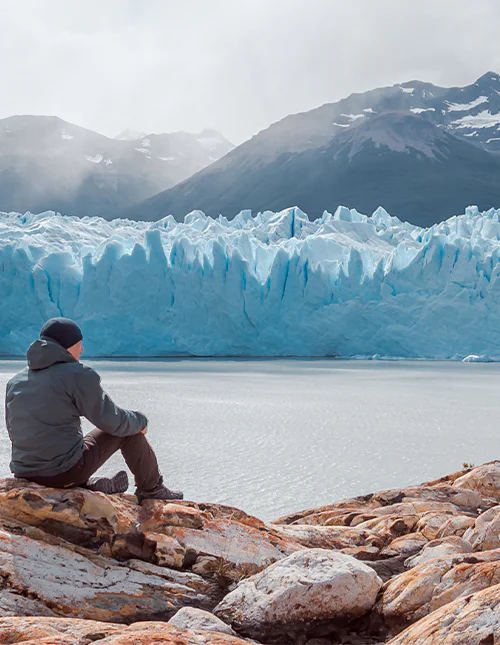 Mann sitter foran Perito Moreno-breen i Los Glaciares nasjonalpark