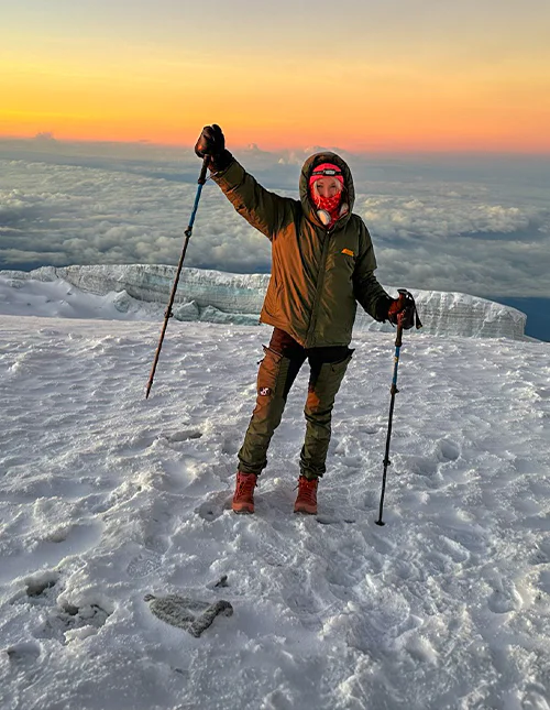 Cat fra TourCompass står på toppen av Kilimanjaro ved soloppgang