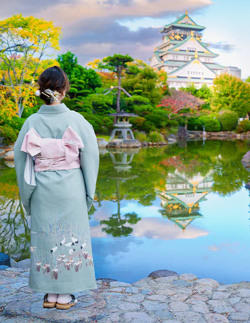 Japansk kvinne foran Osaka Castle