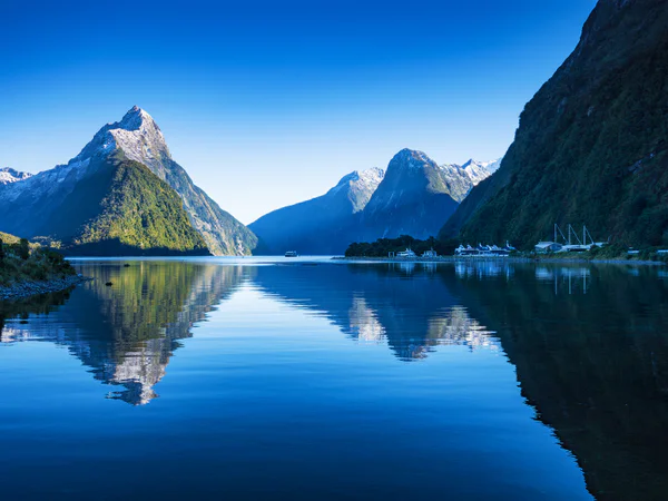 Klar, blå himmel vid Milford Sound i Nya Zeeland