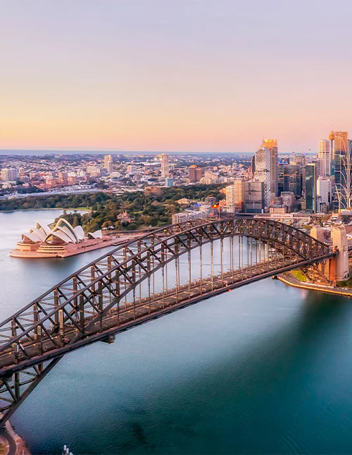 Luftfoto av Sydney Harbour Bridge badet i et lilla skjær.