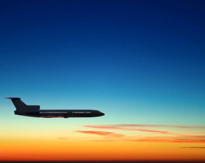Fly på himmel med solnedgang