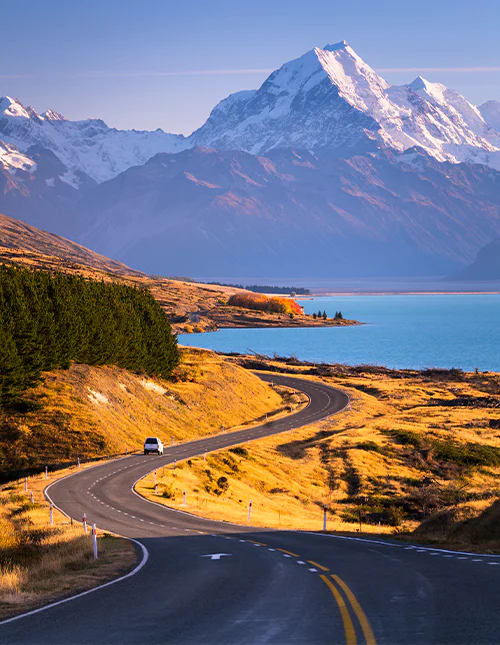 Mount Cook ruver høyt over det blå vannet i Lake Pukaki på Sørøya på New Zealand.