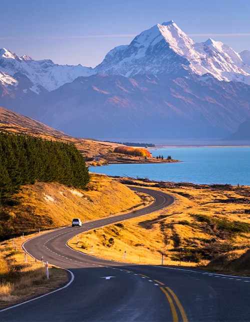 Mount Cook ruver høyt over det blå vannet i Lake Pukaki på Sørøya på New Zealand.
