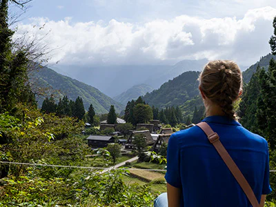 Kvinne ser utover den vakre landsbyen Gokayama