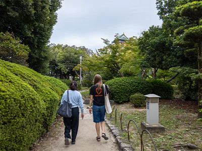 Japansk guide går sammen med en TourCompass-medarbeider ved Osaka Castle i Japan