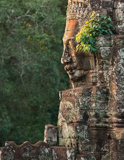 Buddhas ansikt utskåret i stein ved Bayon-tempelet i Kambodsja