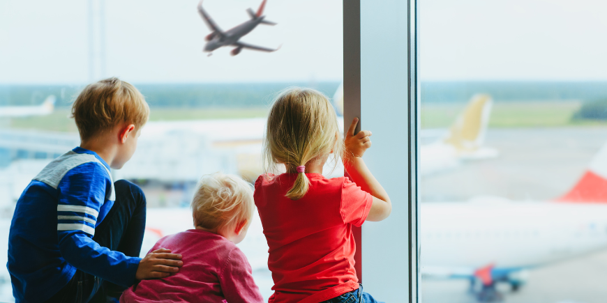 Tre barn som venter på flyplassen