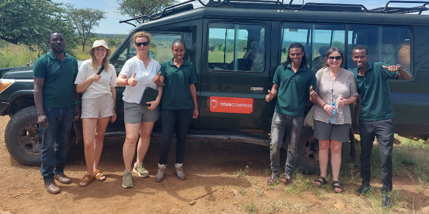 Safarireisende og guider ved safaribil i Afrika