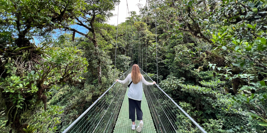 Kvinne stående på Hengebroer i Monteverde, Costa Rica