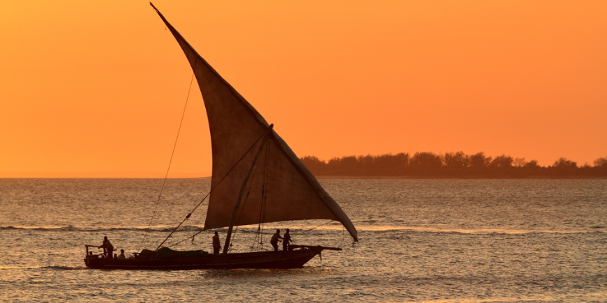 Tradisjonell dhow-seilbåt ved solnedgang i Zanzibar, Tanzania
