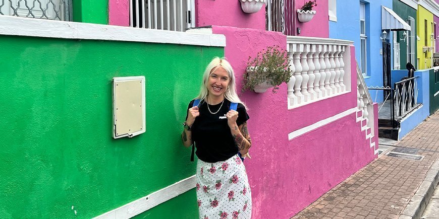 Cat foran de fargerike husene i Bo-Kaap i Cape Town.