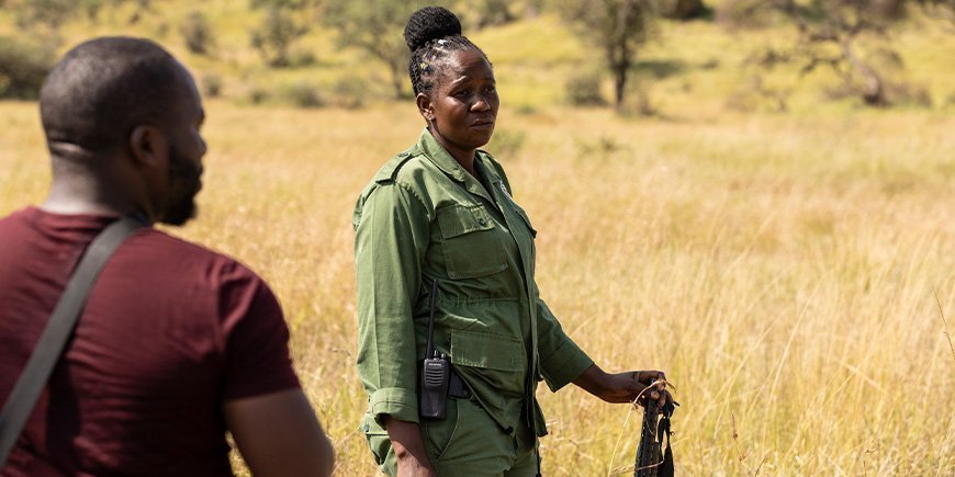 Kvinne med rifle på savannen
