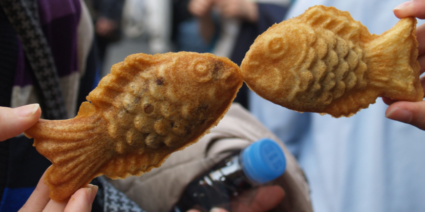 Taiyaki-kaker holdes opp så de ser ut som kyssende fisker