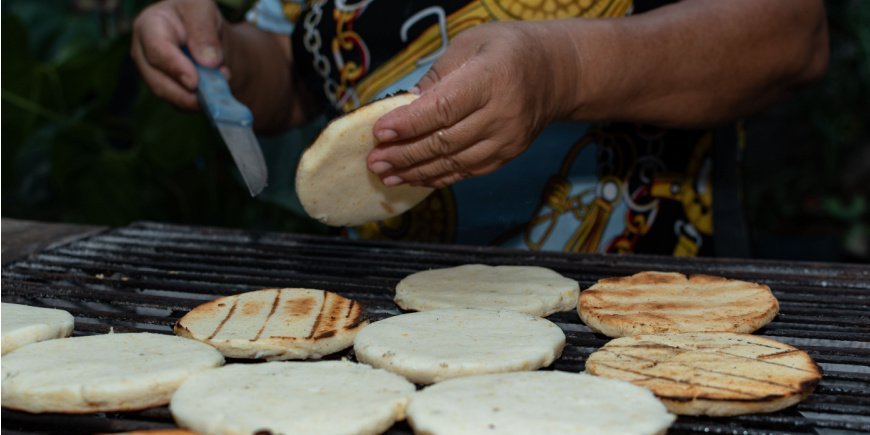 Person som tilbereder arepa på grillen