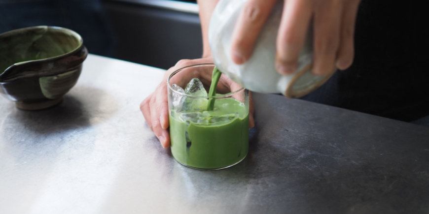 Person heller matcha-te i glas