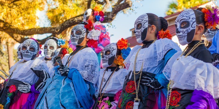 Kvinner i fargerike kostymer med dekorerte kranier til De dødes dag i Mexico