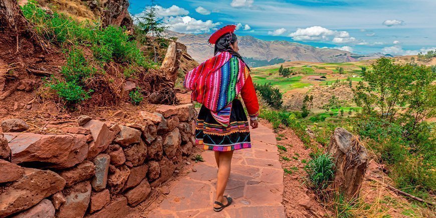 Kvinne fra urbefolkningen går langs en inkamur i Cusco i oktober.