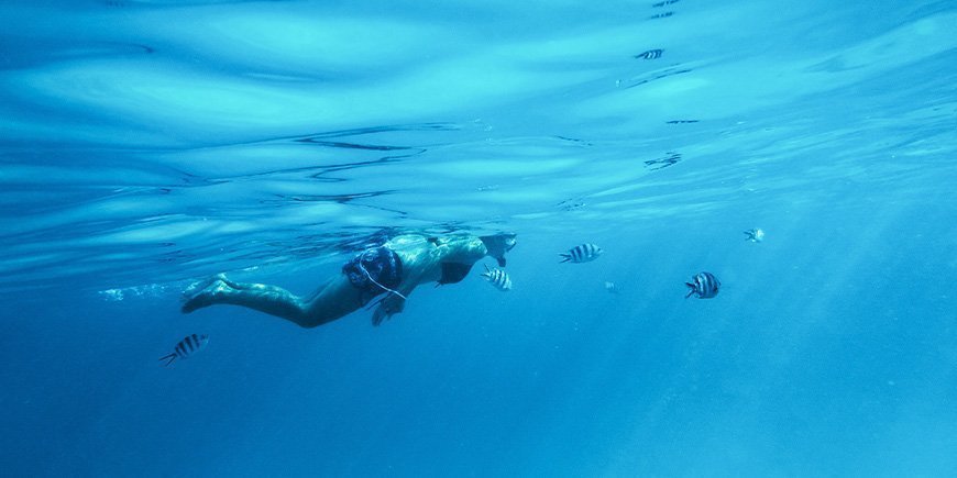 Kvinne som snorkler under vann på Zanzibar