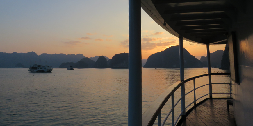 Solnedgang over Ha Long-bukten sett fra en båt