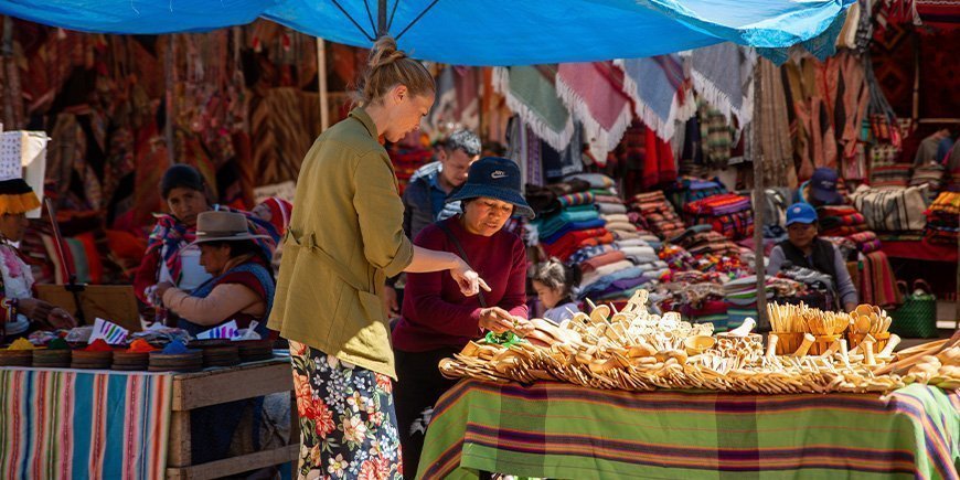 Kvinne kjøper lokale suvenirer i Cusco, Peru