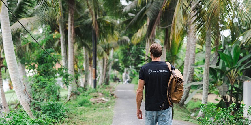 Mann går under palmetrær på Bali i Indonesia