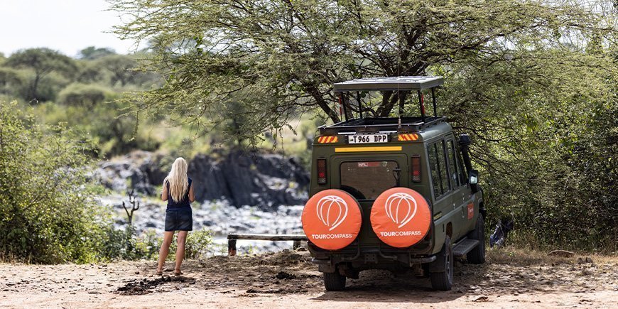 Kvinne og TourCompass-jeep i Tanzania