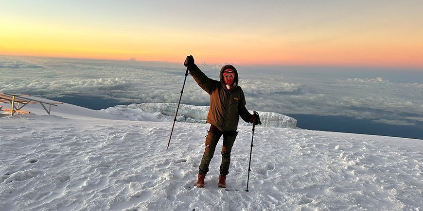 Kvinne i snøen på toppen av Kilimanjaro.