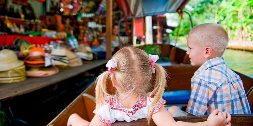 Barn i en båt på Damnoen Saduak-markedet i Thailand