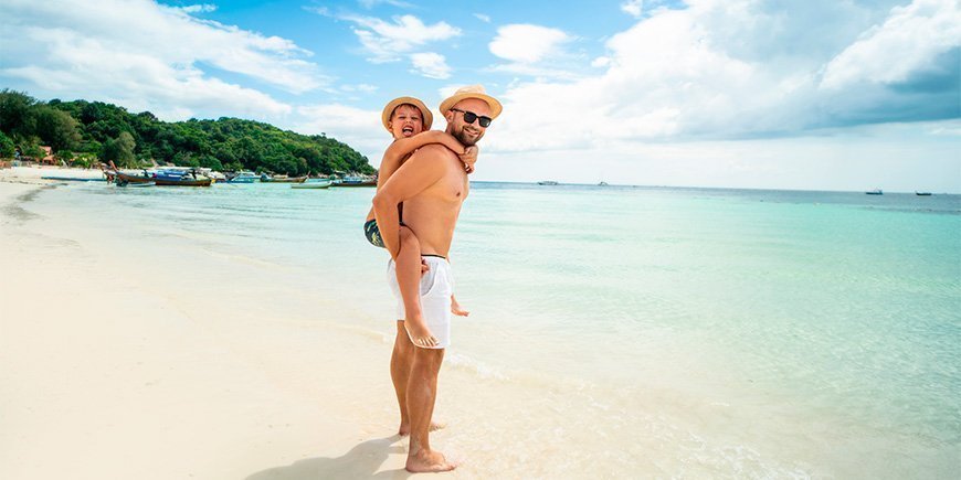 Far og sønn på en strand i Thailand
