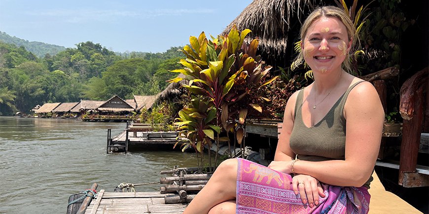 Cecilie fra TourCompass på en benk ved elven Kwai