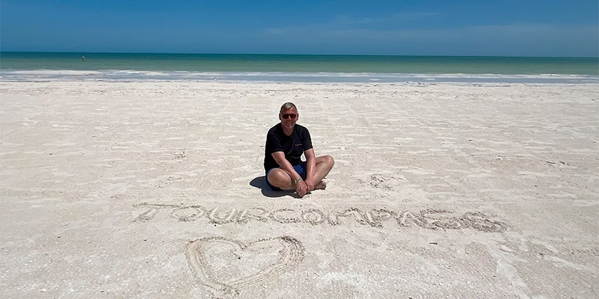 Tom sitter i sanden på Isla Holbox i Mexico