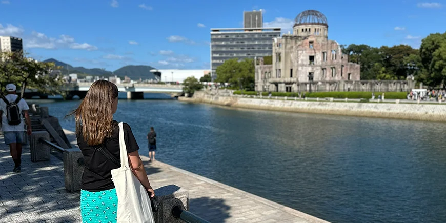 Kvinne som ser på Atombombekuppelen i Hiroshima, Japan.