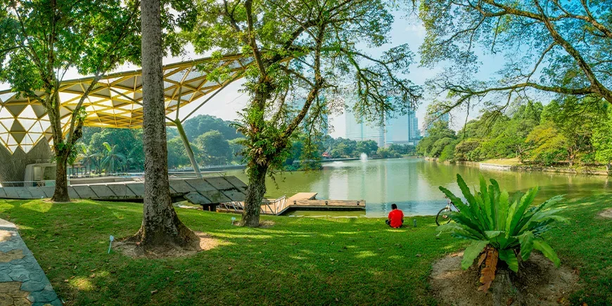 Mann slapper av i parken ved Perdana Botanical Gardens i Kuala Lumpur