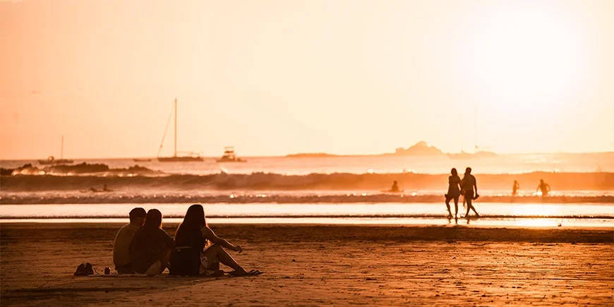 Folk nyter solnedgangen på Tamarindo-stranden i Costa Rica
