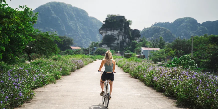 Kvinne sykler på en øde vei i Ninh Binh i Vietnam