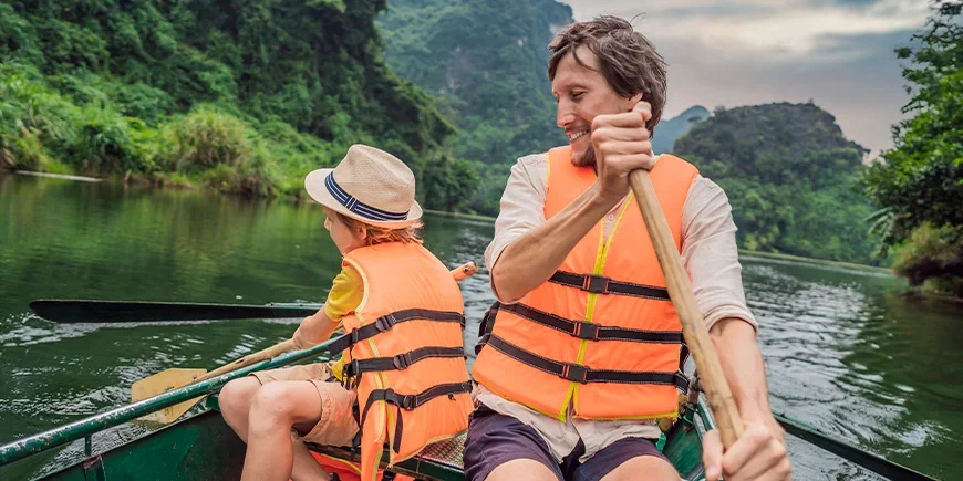 Far og sønn seiler ved Ninh Binh i Vietnam