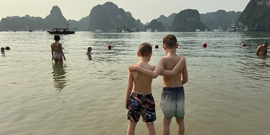 To gutter holder rundt hverandre på en strand i Ha Long-bukten