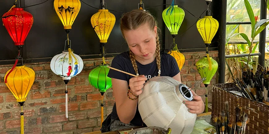 Jente som maler på lanterner i Hoi An i Vietnam