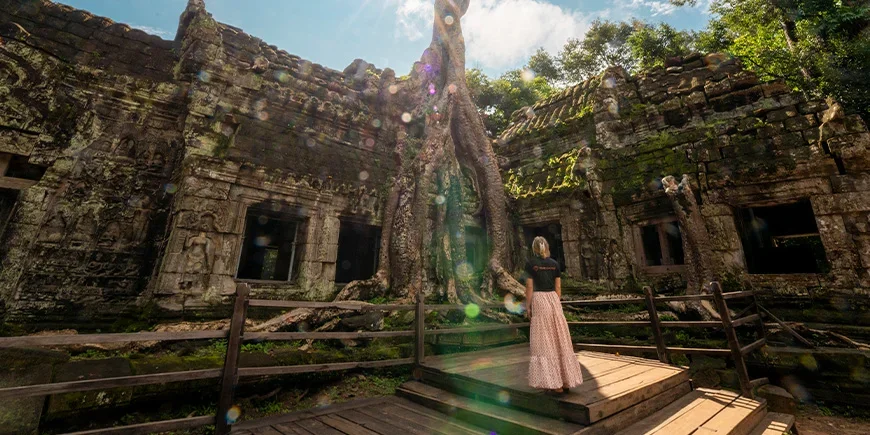 Kvinne i TourCompass-t-skjorte står i Angkor i Kambodsja