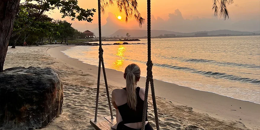 Jente på huske i solnedgangen på stranden på Phu Quoc