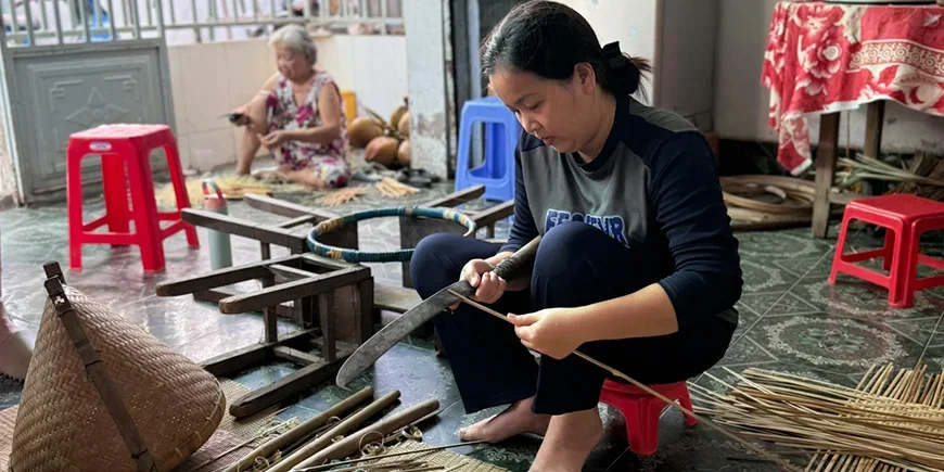 Vietnamesisk kvinne lager produkter av kokos