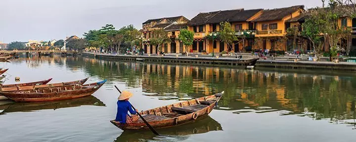 Vietnamesisk kvinne padler i gamlebyen i Hoi An i Vietnam.